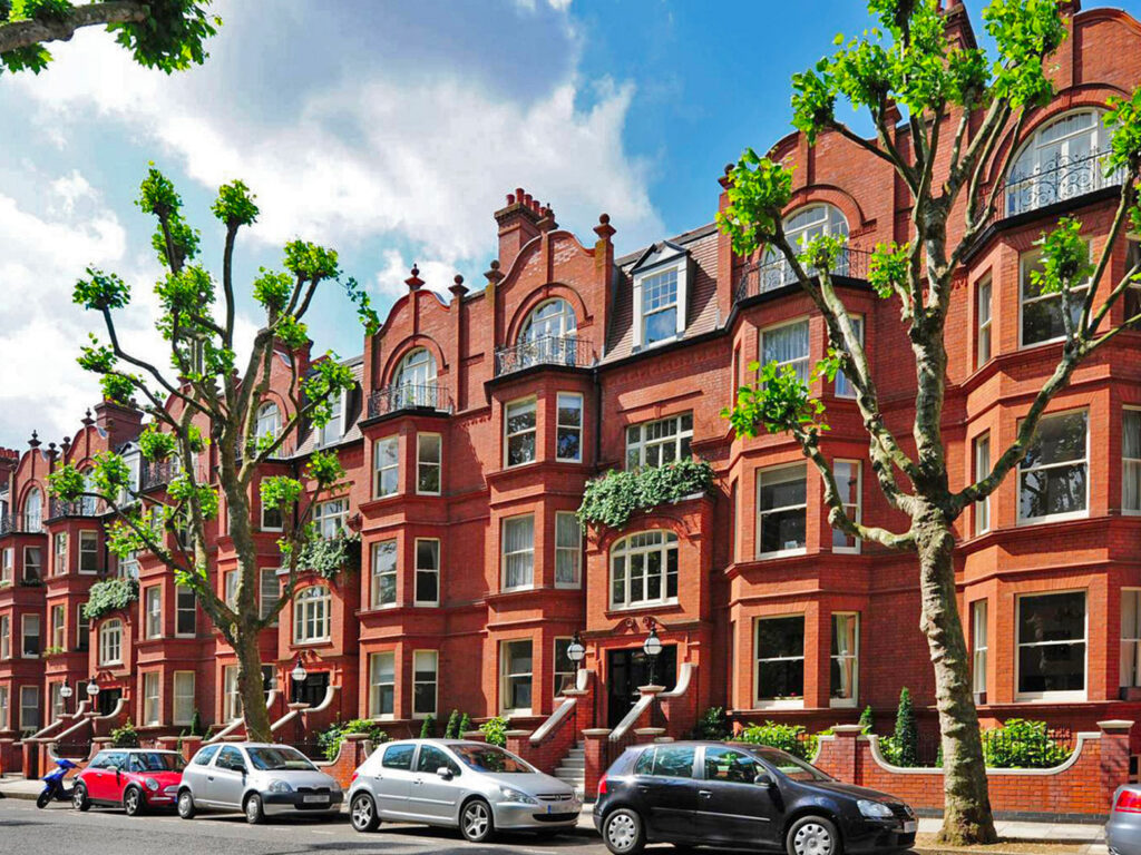 A view of Morshead Mansions in Spring with bright sunshine reflecting from the red bricks