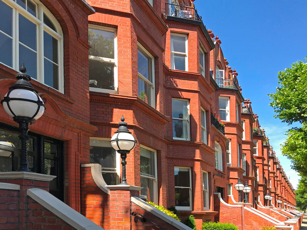 A view down the street of Morshead Mansions, showing the red brick facade in bright morning light