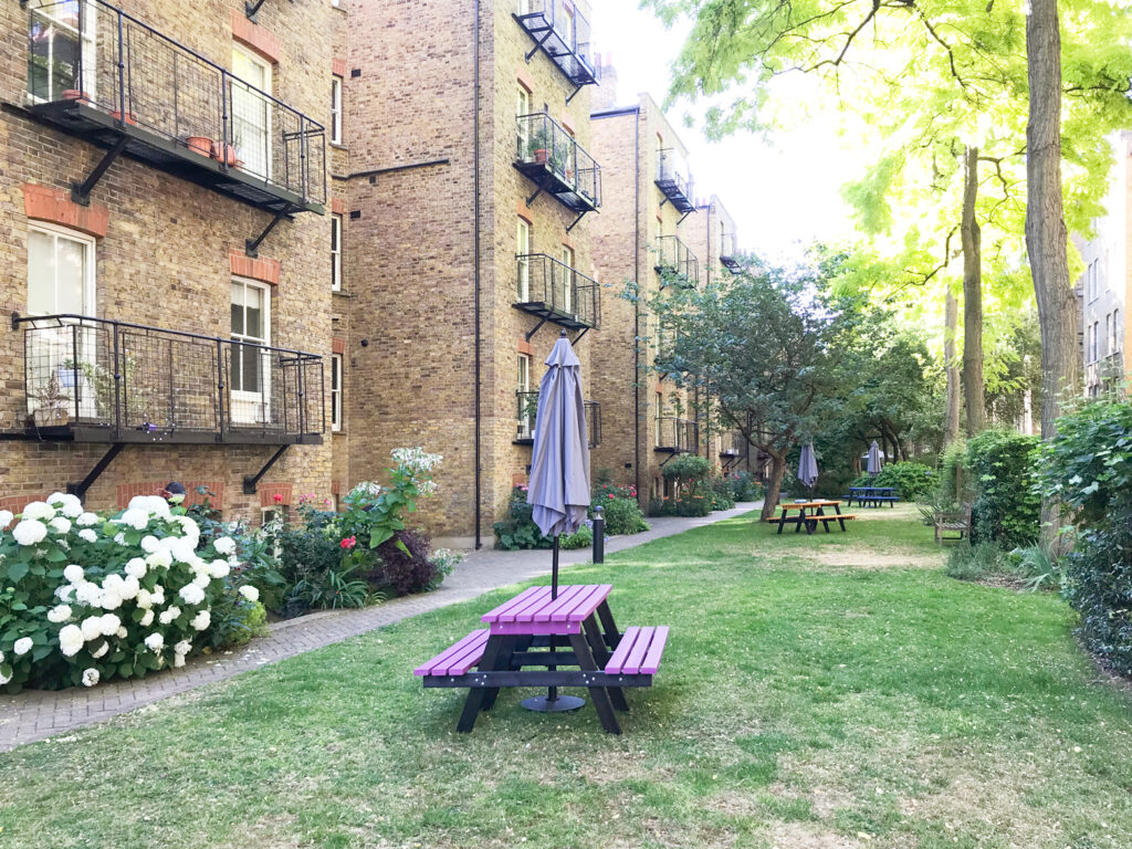 A view of a seating area in the communal gardens at the rear of Morshead Mansions in summer